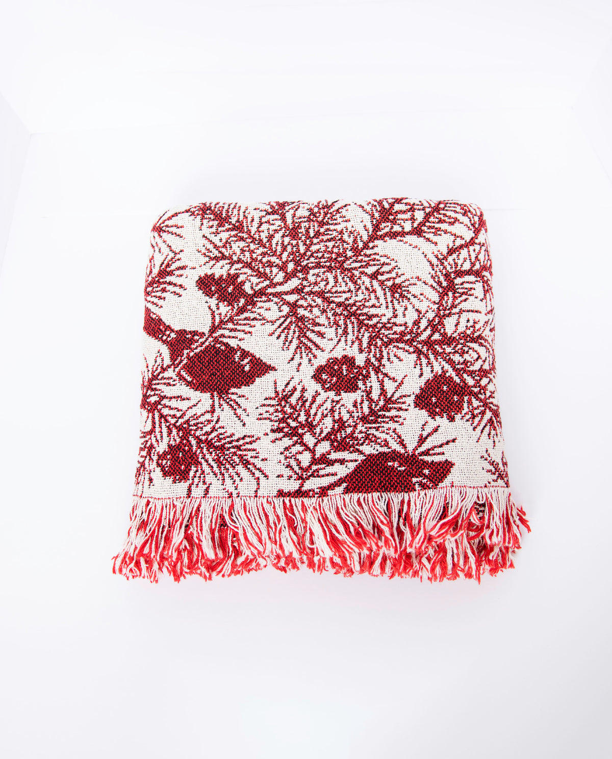 Front view of folded Cherie Cranberry cardinal and pine Christmas throw on a white background