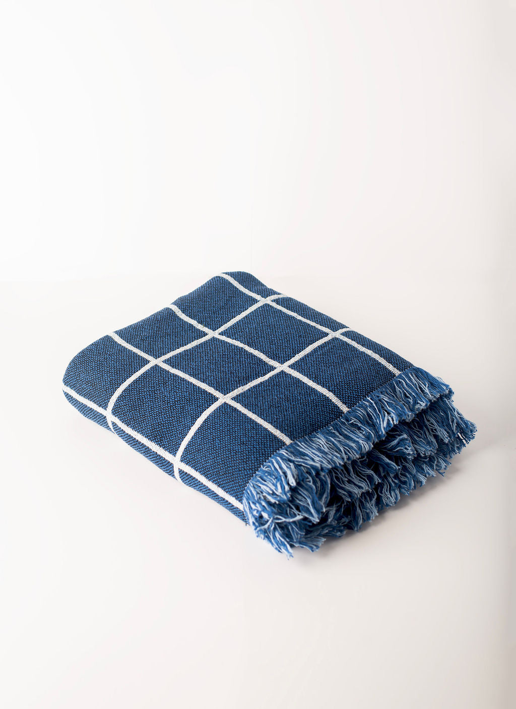 Folded Greer Lapis blue grid reversible jacquard woven throw blanket